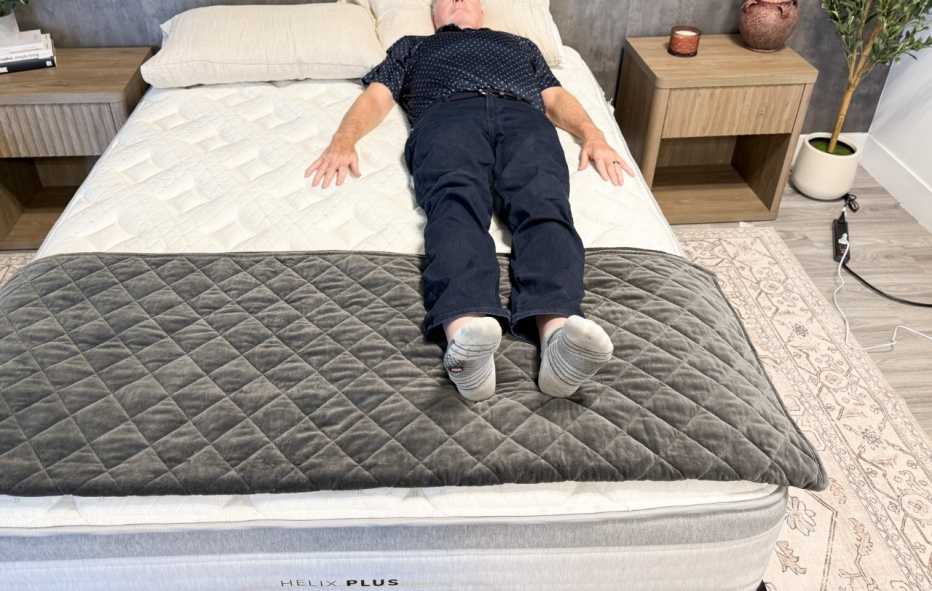 A man lying on his back on the Helix Plus mattress.