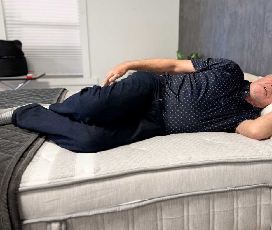 A man lying on his side on the Leesa Plus Hybrid.