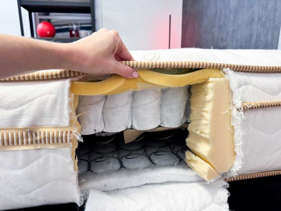 The construction of the Saatva Classic mattress seen through a cut out in the side of the bed
