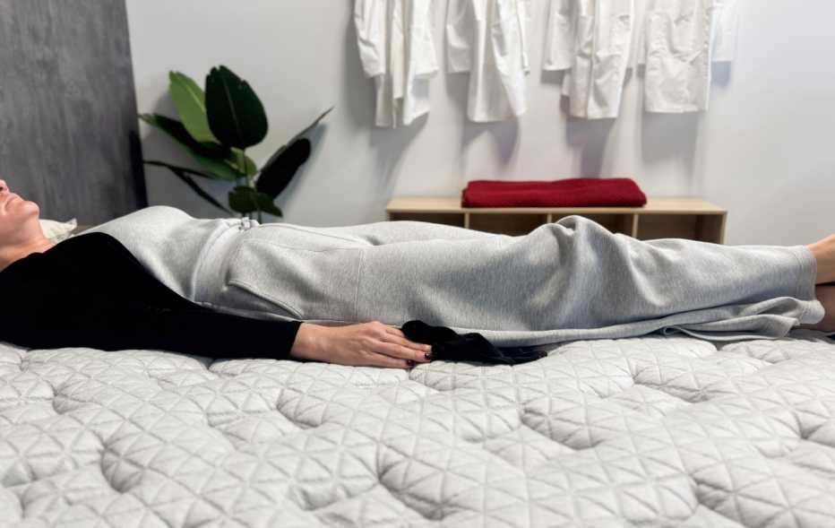 Woman lies on her back on a mattress
