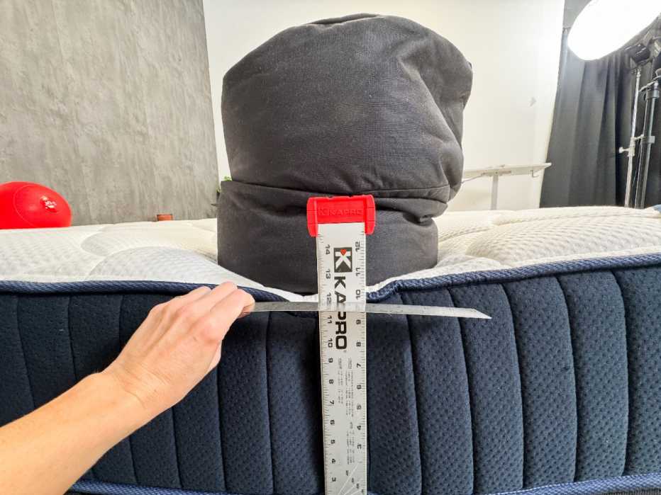 Measuring how many inches the edge of a mattress sinks under a 150-pound sandbag