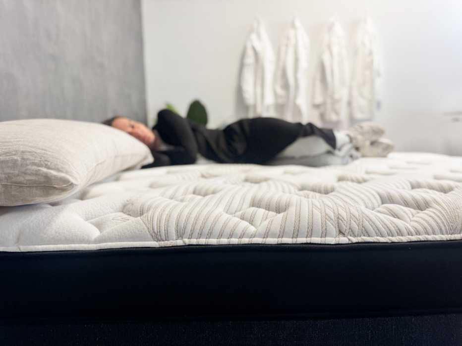 Woman lies on her side on the Nolah Evolution Luxury Firm mattress