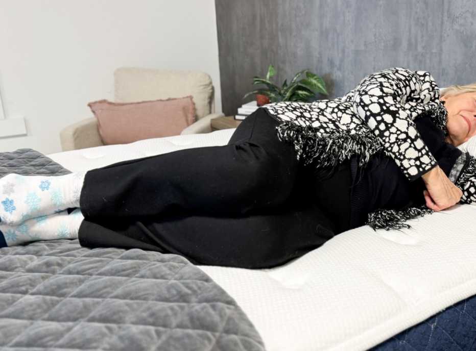 Woman lying on her side on the Brooklyn Bedding Signature mattress.
