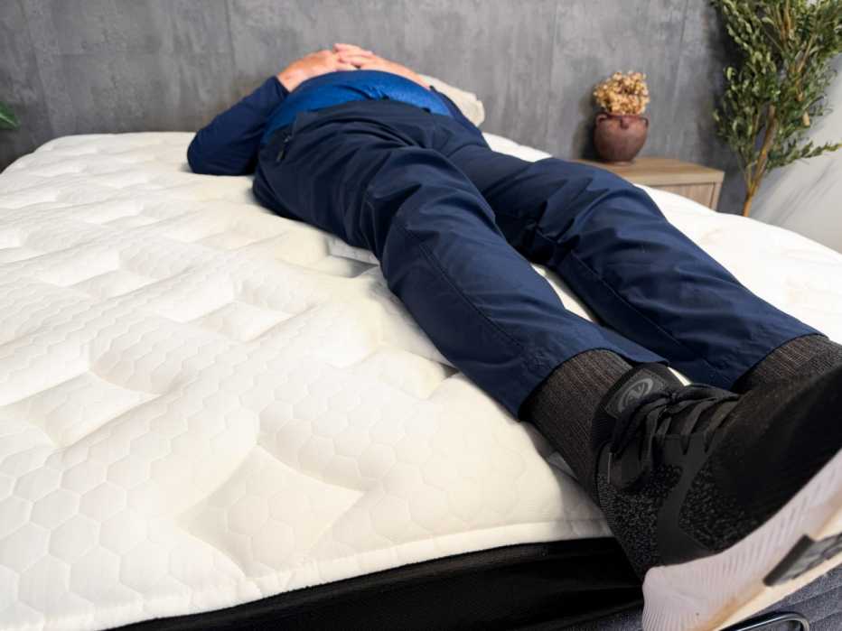 An older adult tester lying on his back on the Nolah Comfort Plus mattress.
