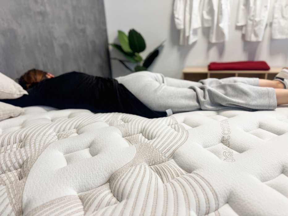 A woman lies on her stomach on a mattress