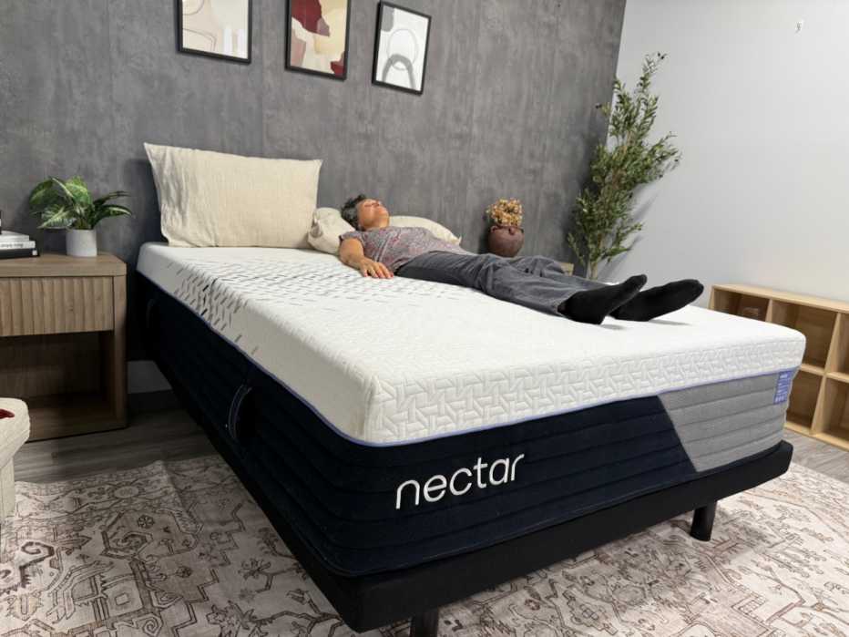 A woman lying on her back on the Nectar Luxe Hybrid mattress.