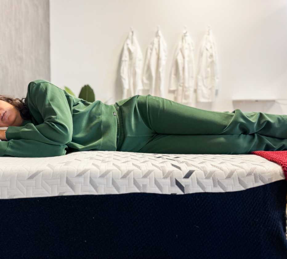 Woman lies on her side on a mattress