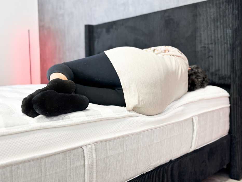 A woman lying on the edge of the Leesa Sapira Chill mattress.
