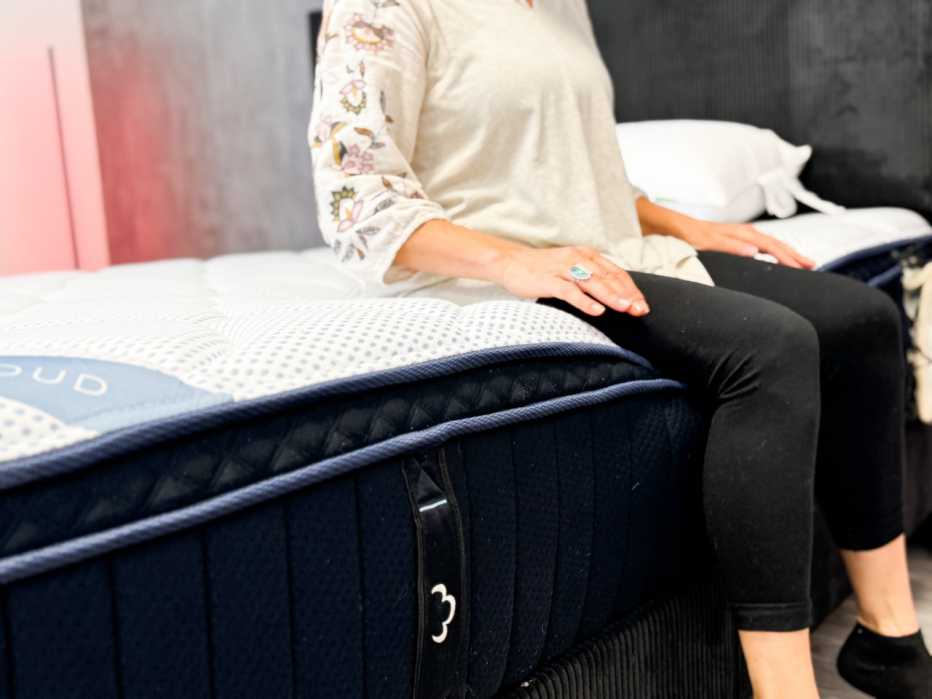 a woman is sitting on a mattress during a test