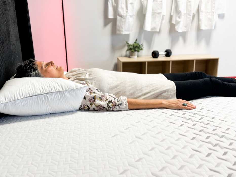 A woman lying on her back on the Nectar Premier Memory Foam mattress.