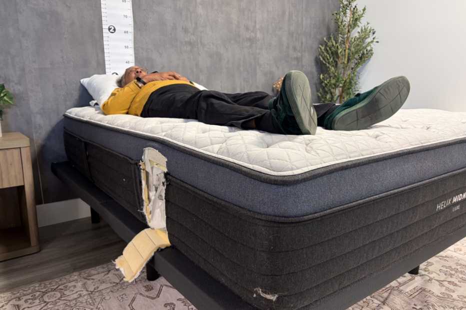 A woman lying on her back on the Helix Midnight Luxe mattress.