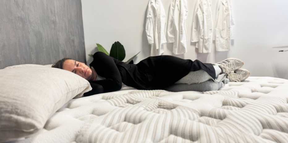Woman lies on her side on a mattress