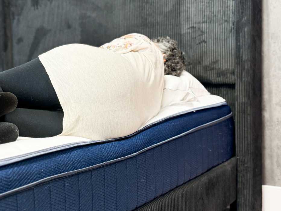 Woman lays near the edge of a mattress