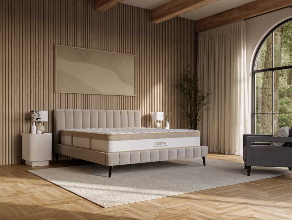 The Saatva Memory Foam Hybrid mattress in a bright bedroom with big windows