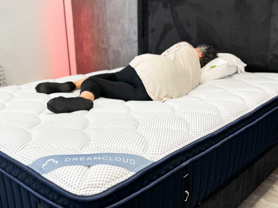 A woman lying on her side on the DreamCloud Premier mattress
