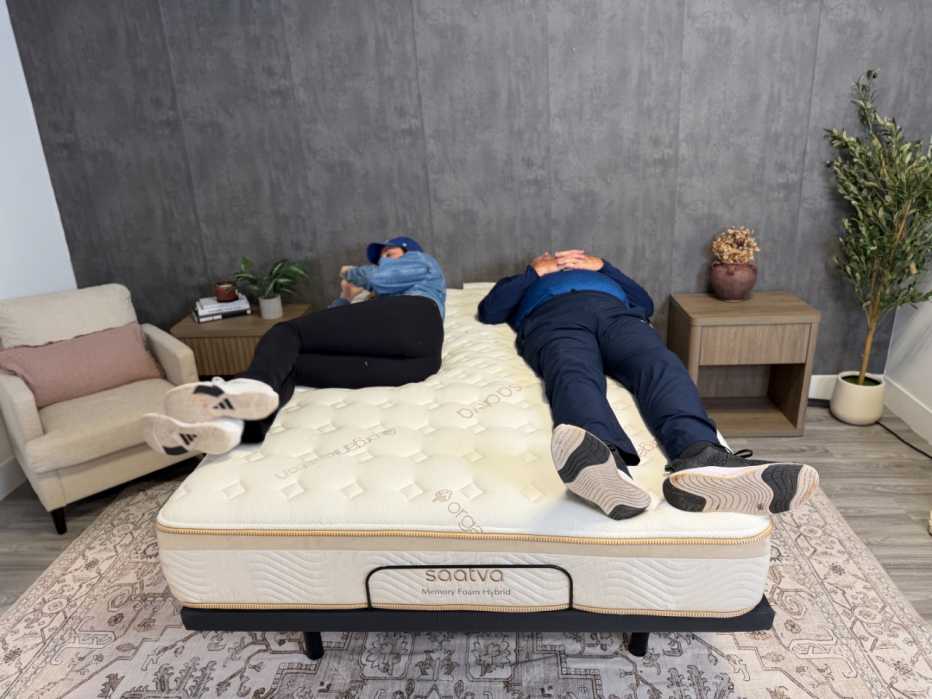 Two people lying on the Saatva Memory Foam Hybrid bed.
