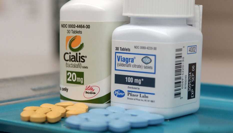 Cialis and Viagra pill bottles with pills on a tray. Cialis and Viagra pill bottles with pills on a tray.