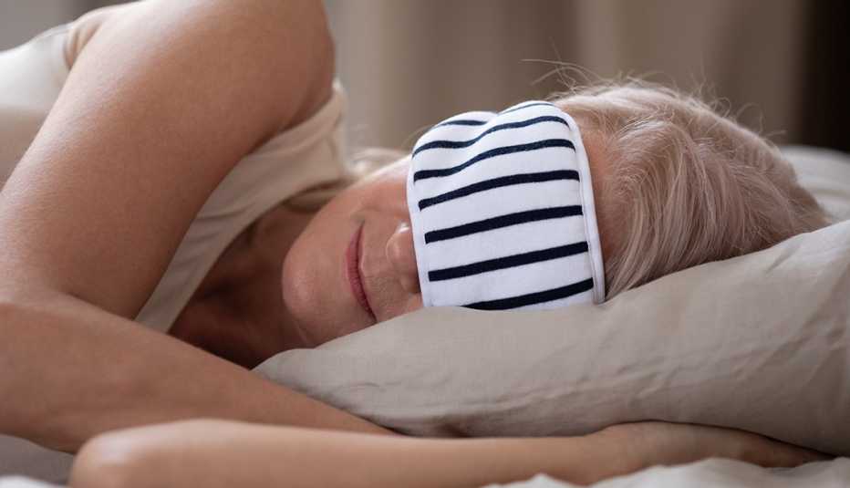 woman wearing a sleep mask while sleeping at a hotel