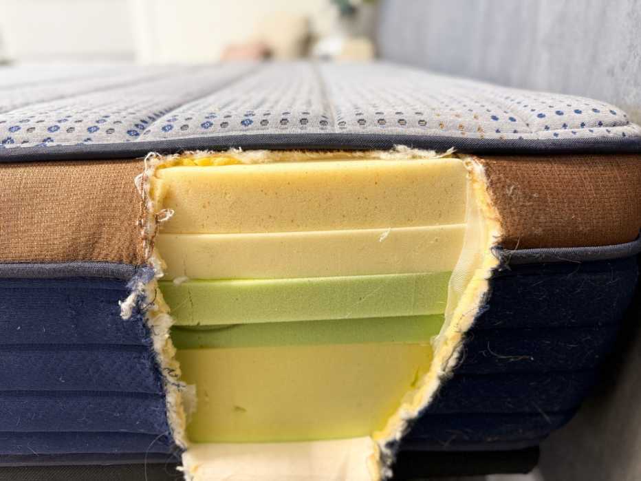 Hole cut open in the side of a Brooklyn Bedding memory foam mattress showing five layers of dense memory foam. 