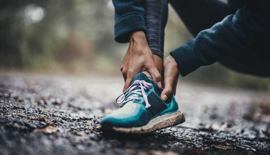 woman holding injured ankle