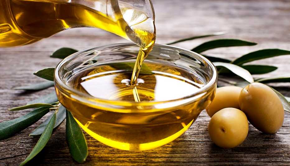 bottle pouring olive oil into a bowl