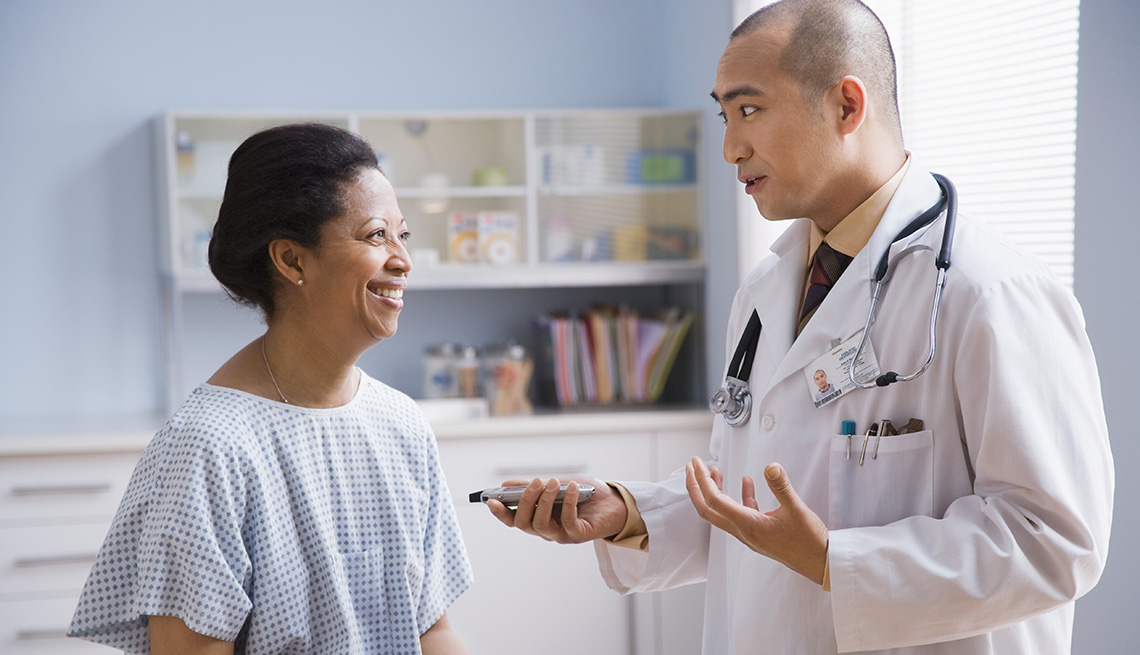 Mature African American woman in a doctor's office speaking with her doctor.