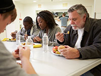 elderly man having a meal at a homeless shelter 