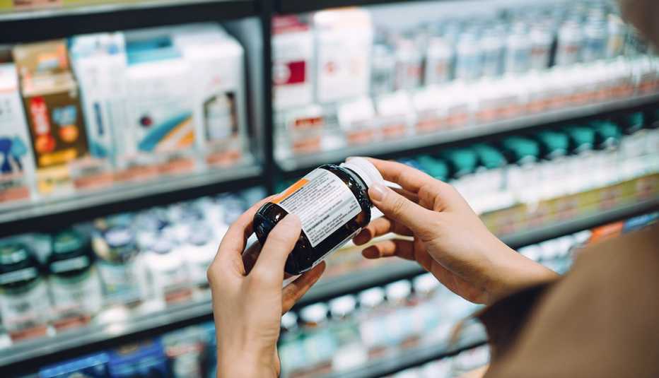 person reads label on vitamin bottle