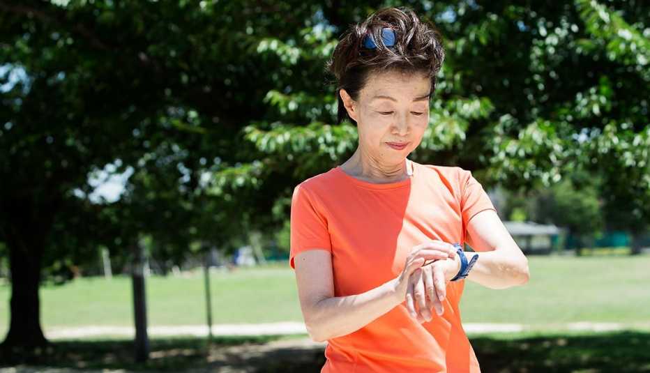 woman looks at her watch as she contemplates a run