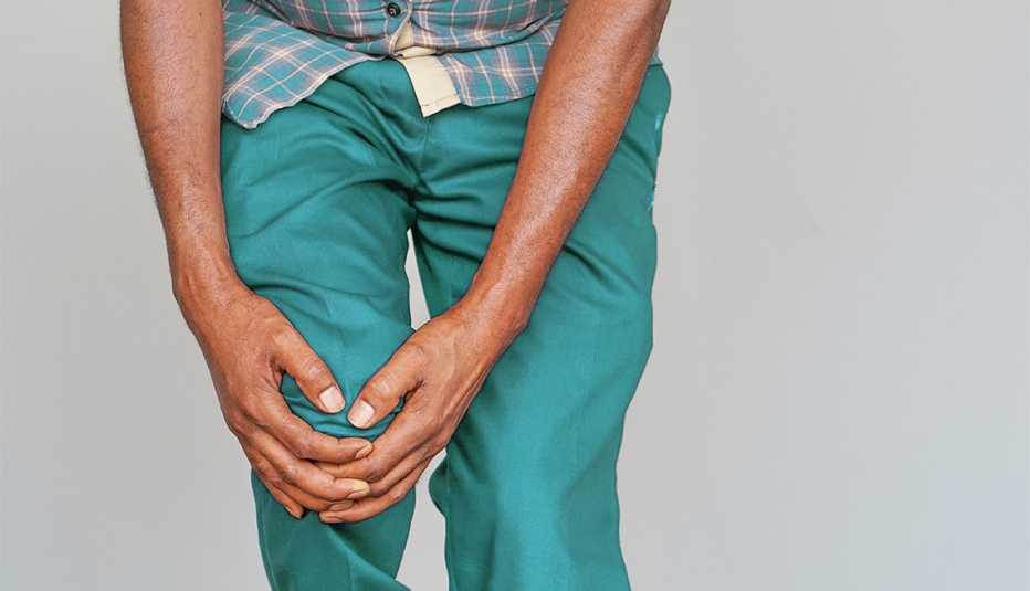 Senior African American man suffering from knee pain. 