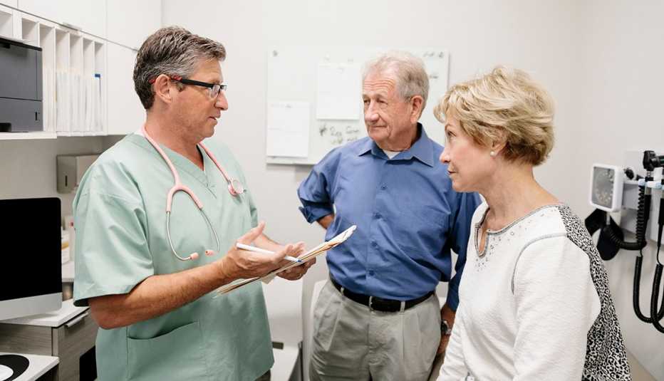 A doctor is speaking to a couple in an examination room