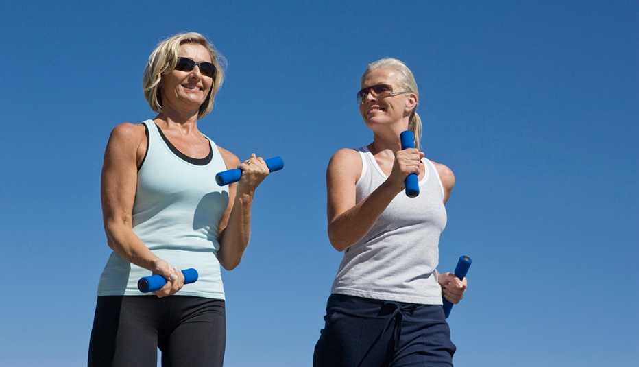 two women walking with weights in their hands