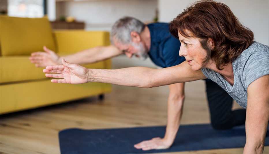 A couple indoors at home, doing exercise on the floor