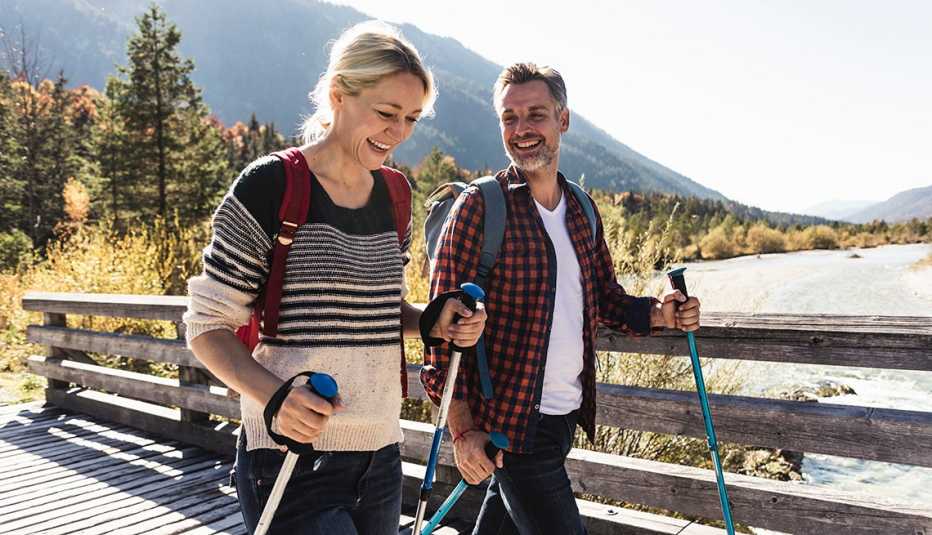 couple hiking across a bridge