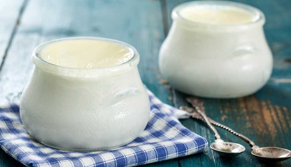 yogurt in two jars sitting on a teal table yogurt in two jars sitting on a teal table