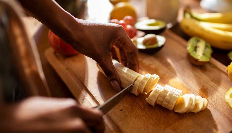 close up of a woman chopping a banana close up of a woman chopping a banana