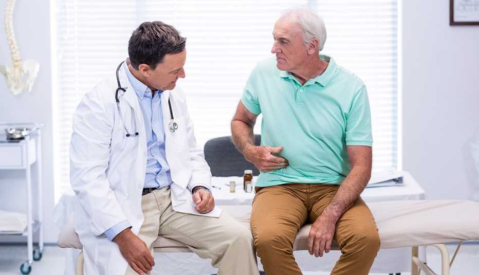 A man shows stomach pain to male doctor
