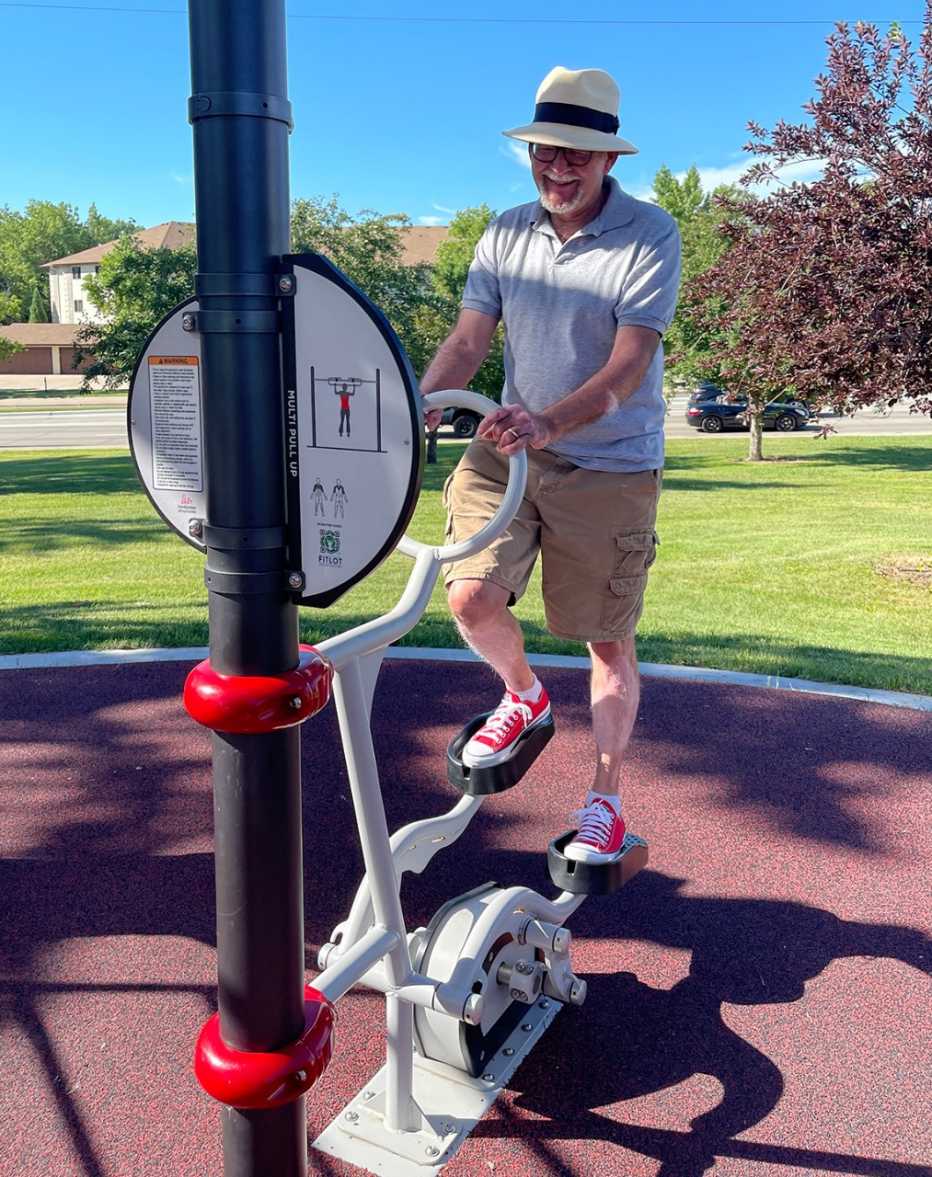 photo of a man on a stair climbing machine at the outdoor North Dakota FitLot fitness park adventure playground for adults and one of many fun ways to exercise for older adults in the area