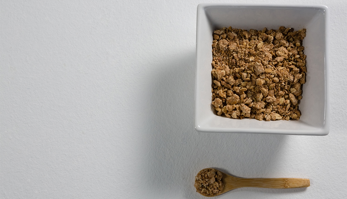 Bowl of Grape-Nuts with spoon on white background