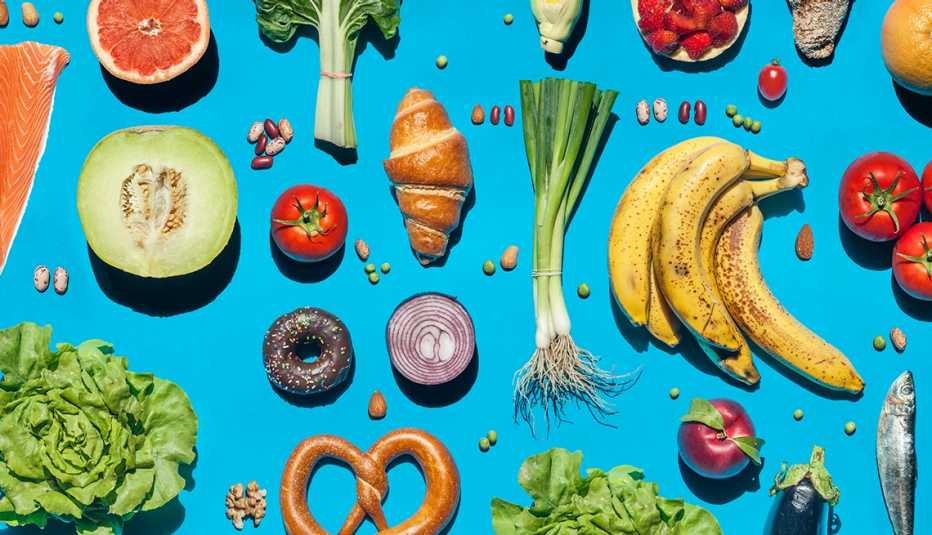 blue background table filled with various foods and featuring colorful fruits and vegetables as the highlights