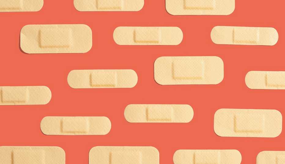 rows of band aids of varying sizes are stuck to a background in rows