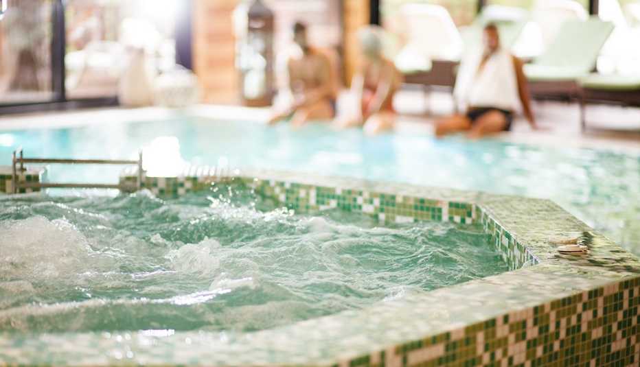 Close-up shot of hot tub at spa. People sitting on poolside in the background.