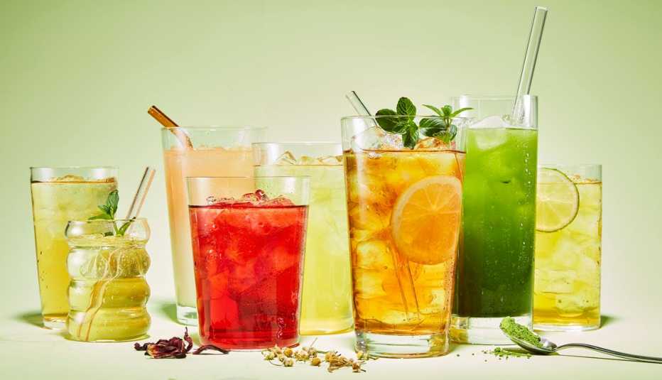 ice teas of various colors and flavors arranged with ingredients