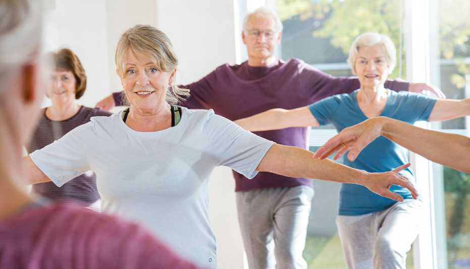 group of people doing a balance exercise in a fitness class