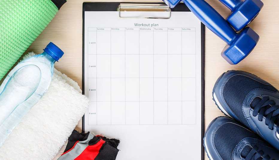 Workout plan with dumbbells, sneakers, water bottle and mat