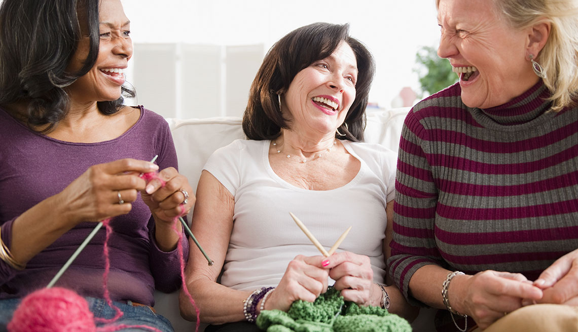 Friends laughing and knitting together