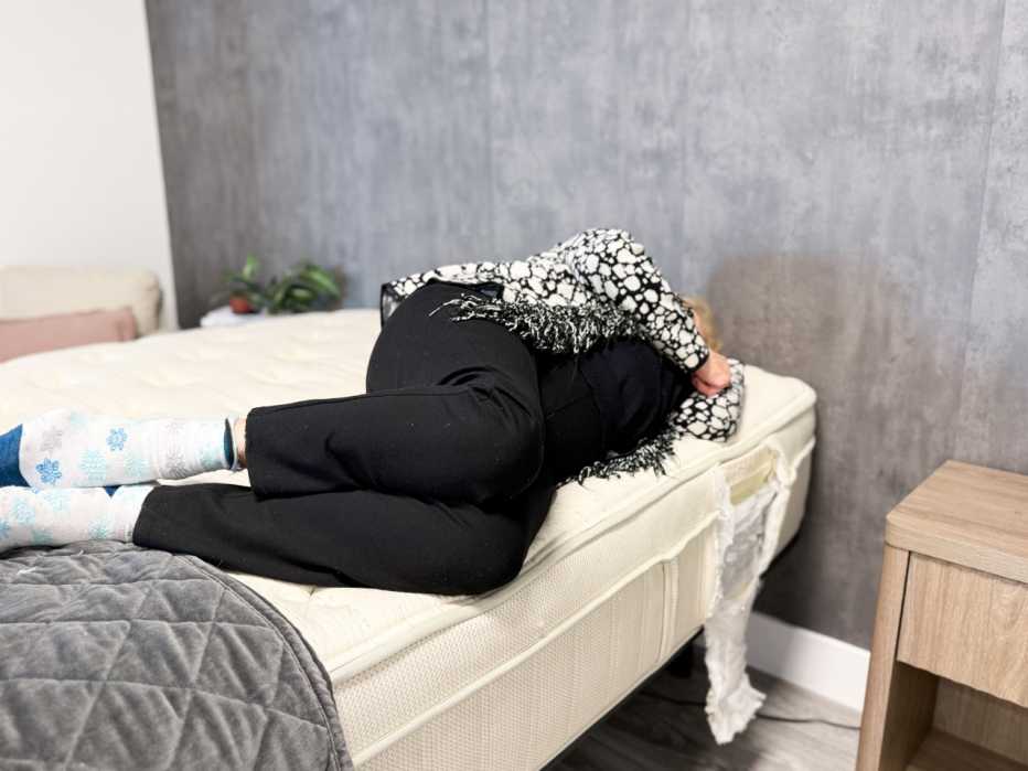  A woman lying on her side on the Leesa Natural mattress.