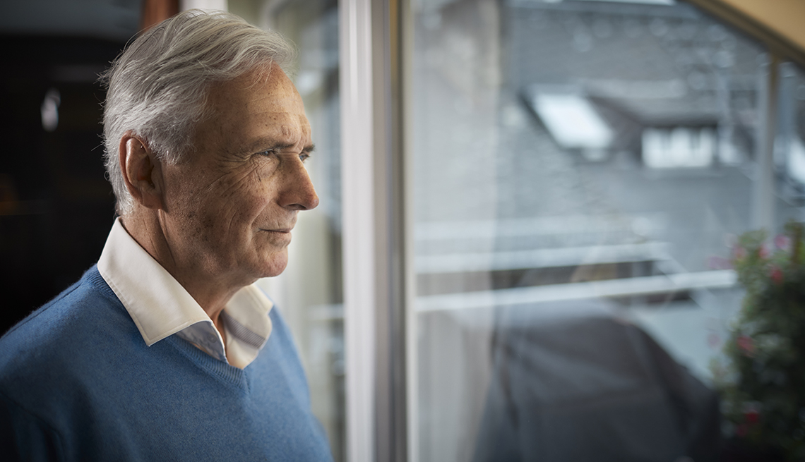 older man staring out of a window