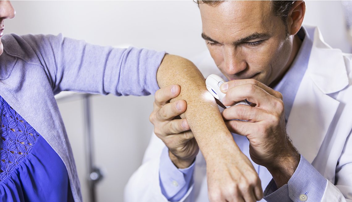 dermatologist examining a female patient's skin 
