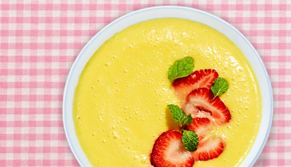 bowl of mango coconut soup on a table bowl of mango coconut soup on a table